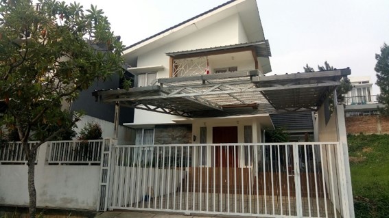 Tampak depan rumah tinggal di Kelapa Gading dengan kanopi kayu dan pagar putih
